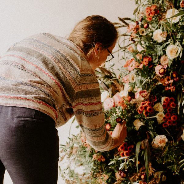 Femme réalisant un bouquet de fleurs